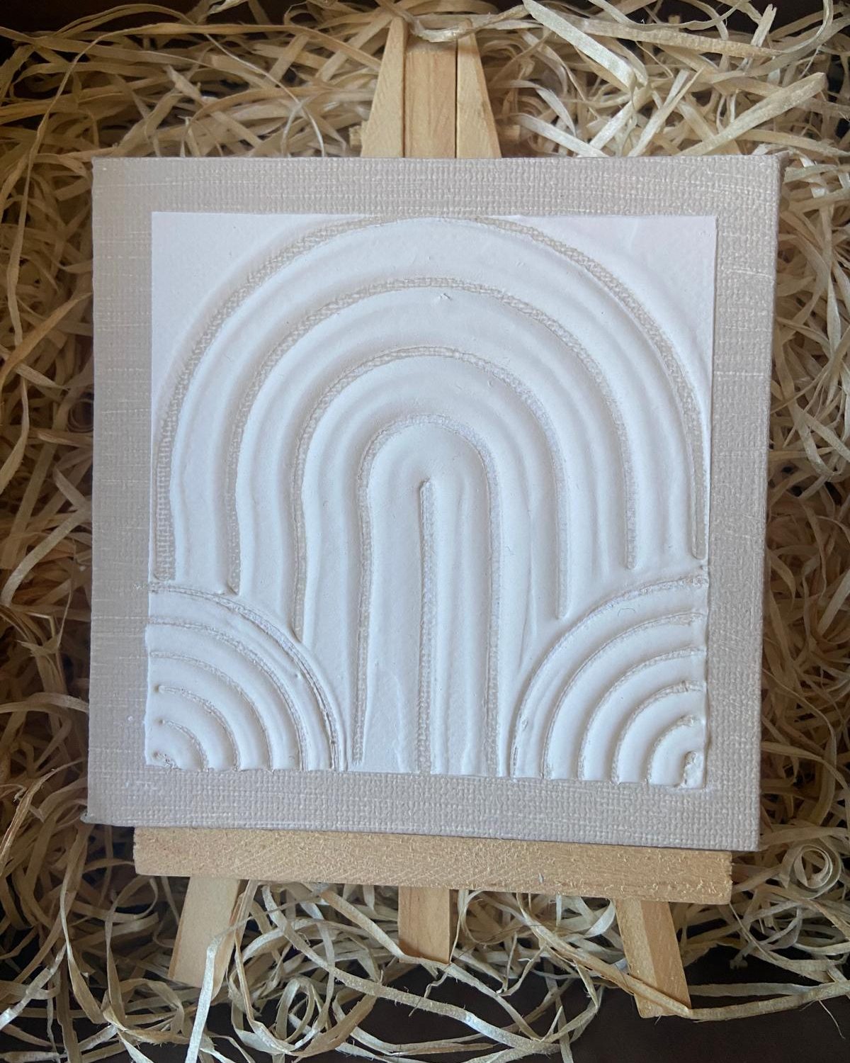 Mini cuadro con relieve de arcos sobre un caballete