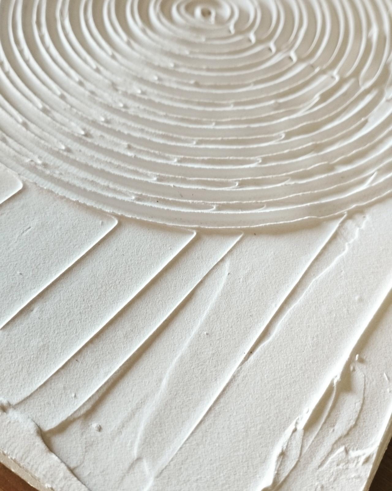 Detalle del relieve en espiral de un cuadro blanco
