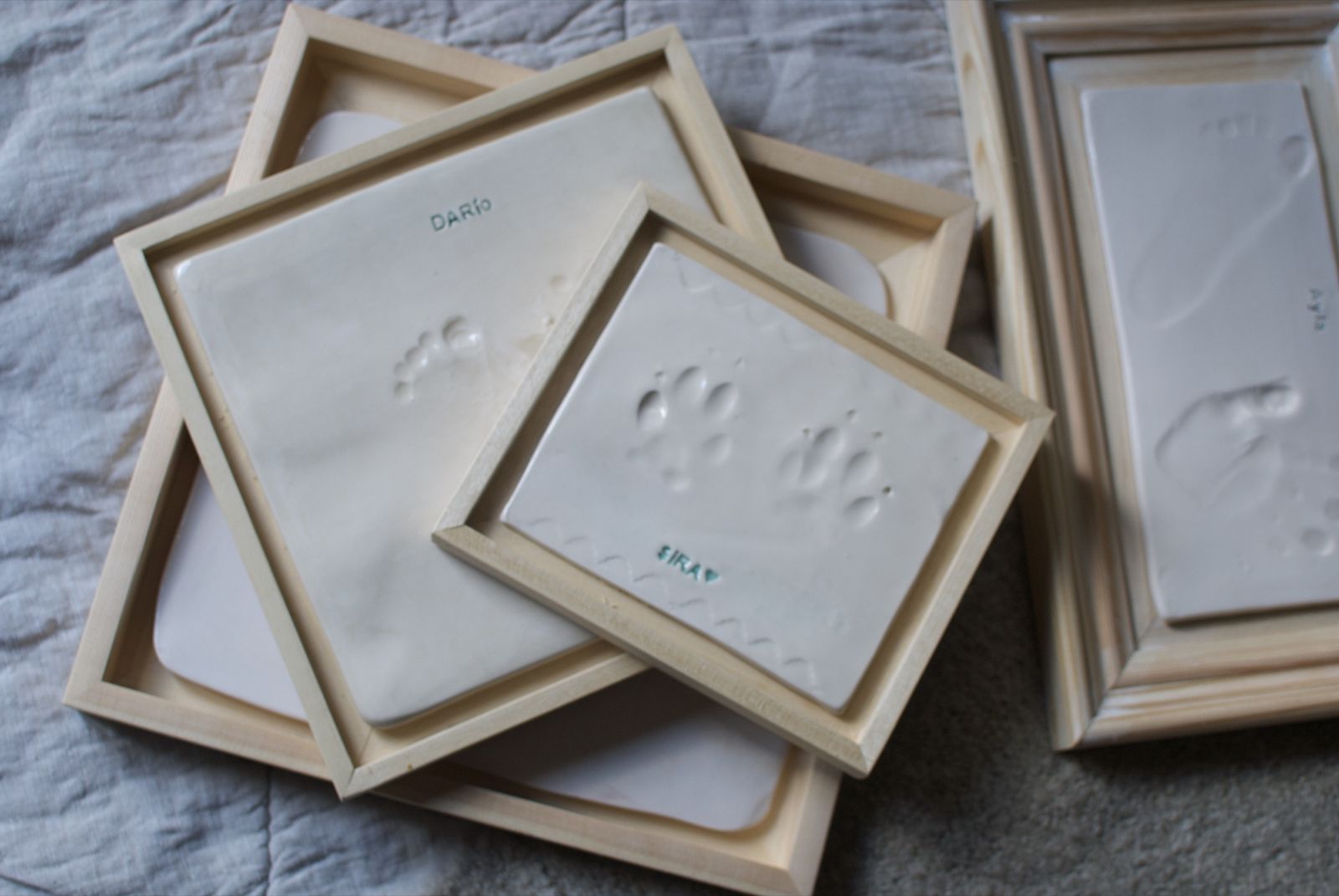 Varias placas de huellitas con nombre en marcos de madera