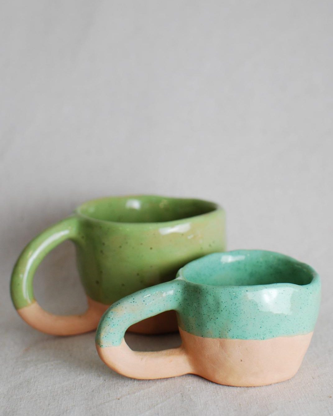 Tazas verde y turquesa con base de barro natural