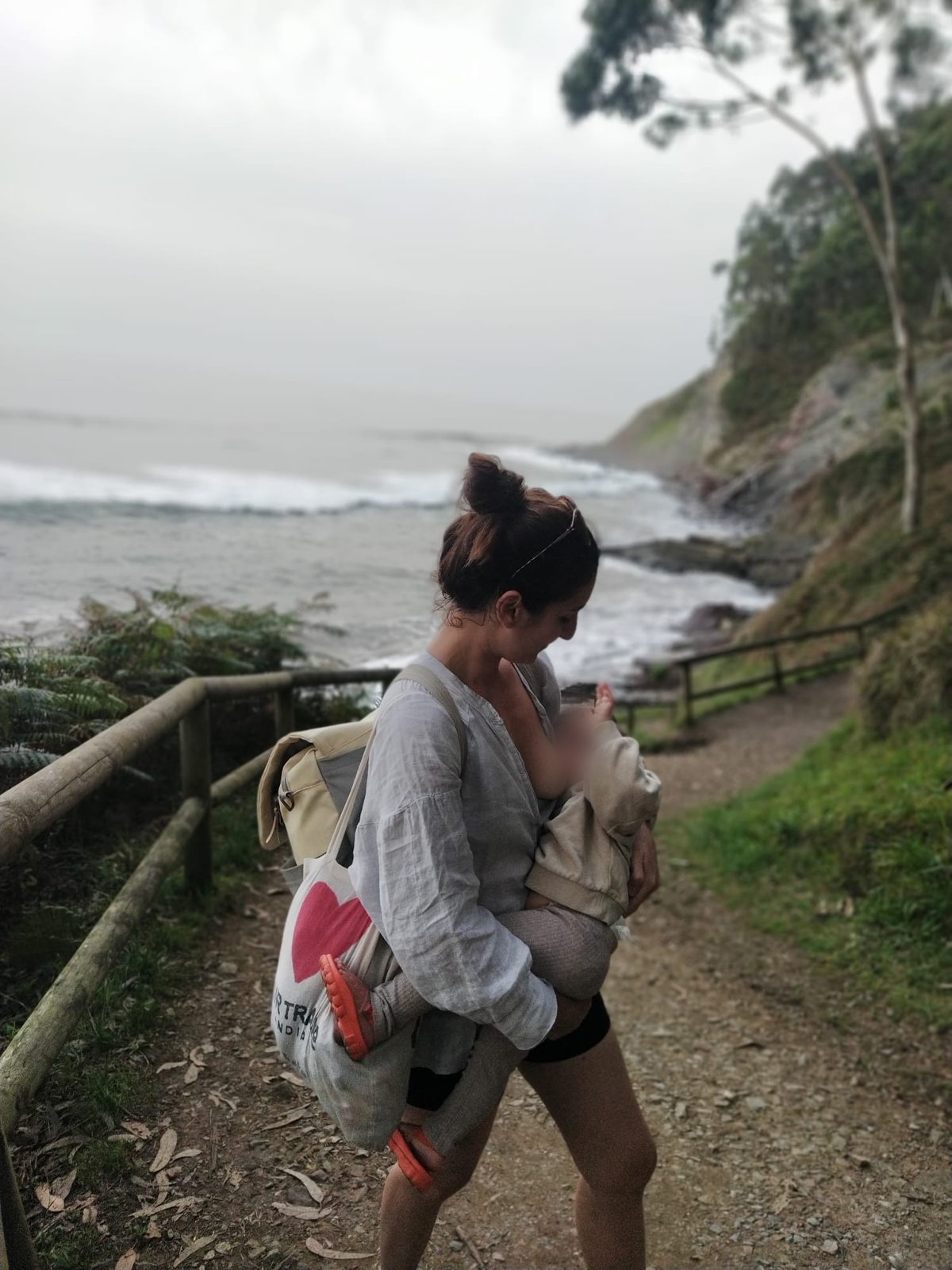 La artesana de Pupu Studio con su hija en brazos junto al mar